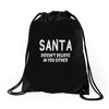 santa doesn't believe in you either Drawstring Bags