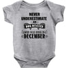 never underestimate an old man who was born in december Baby Onesie