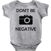 don't be negative camera Baby Onesie